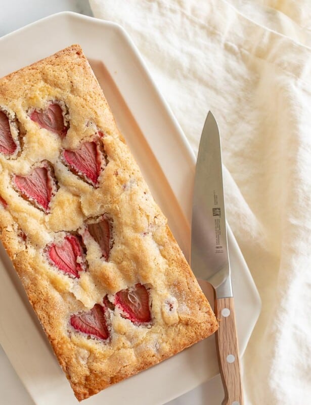 一个象牙盘新鲜的草莓面包刀。